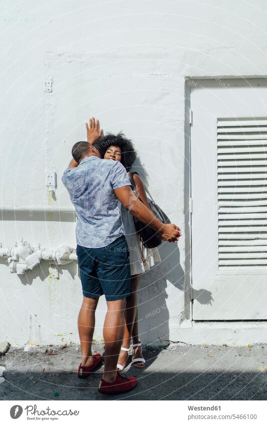 Verliebtes junges Paar am Gebäude stehend steht Zuneigung Pärchen Paare Partnerschaft Mensch Menschen Leute People Personen Bauwerk Bauwerke Miami Beach