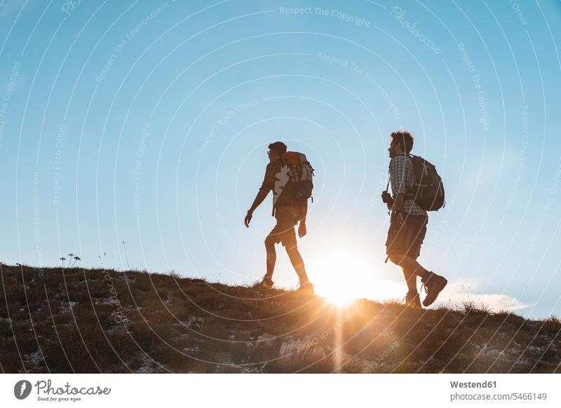 Italien, Monte Nerone, zwei Männer wandern in den Bergen bei Sonnenuntergang Sonnenuntergänge gehen gehend geht Mann männlich Wanderer Wanderung Gebirge