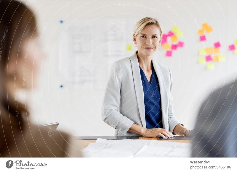 Porträt einer selbstbewussten Geschäftsfrau im Konferenzraum Team Beruf Papier arbeiten stehen Anführen Konzeption modern Planung Zusammenarbeit Agentur