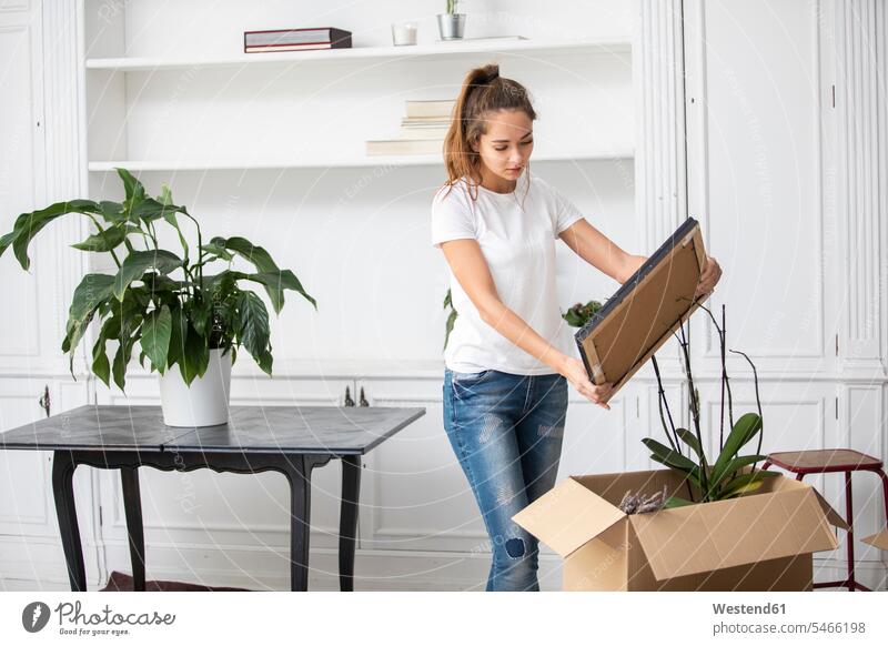 Frau packt Kartons Wohnung Mietwohnungen wohnen weiblich Frauen Zuhause zu Hause daheim Umzug umziehen packen einpacken Pappkartons Erwachsener erwachsen Mensch