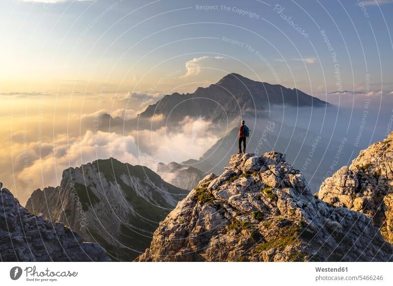 Wanderer bewundert atemberaubende Aussicht auf dem Berggipfel der Bergamasker Alpen, Italien Farbaufnahme Farbe Farbfoto Farbphoto Außenaufnahme außen draußen