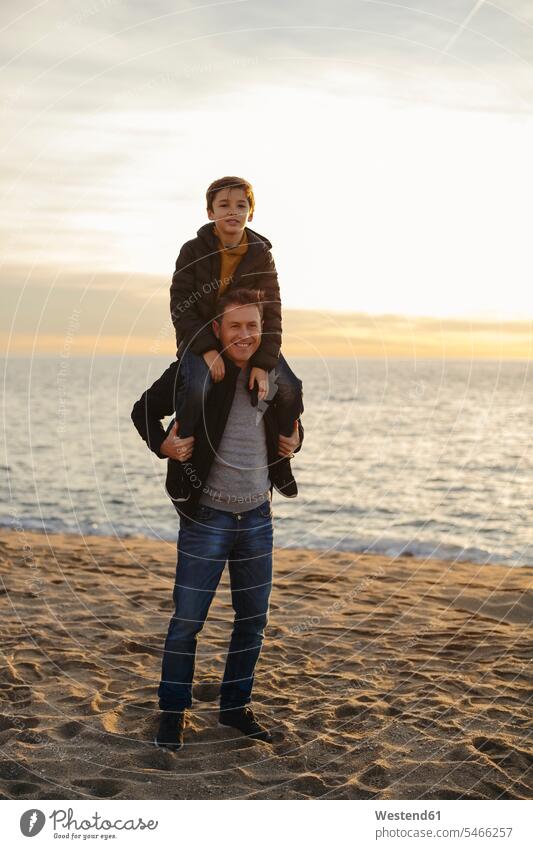 Porträt eines Vaters, der seinen Sohn huckepack am Strand trägt Söhne Huckepack Papas Väter Vati Vatis Papis Portrait Porträts Portraits Beach Straende Strände