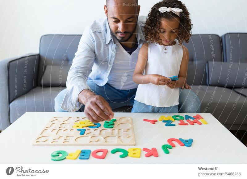 Vater und Tochter spielen zu Hause mit Alphabet-Lernspiel Leute Menschen People Person Personen gemischtrassig 2 2 Menschen 2 Personen zwei Zwei Menschen