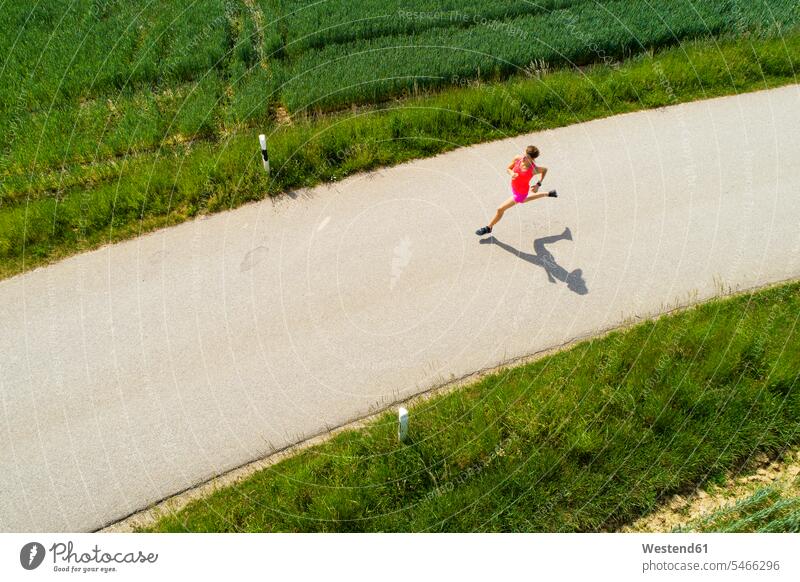 Junge Frau beim Joggen aktiv Joggerin Joggerinnen Jogging laufen rennen Ausdauer Ausdauernd weiblich Frauen Trainieren Übung Üben Übungen Aktivität Aktivitaet