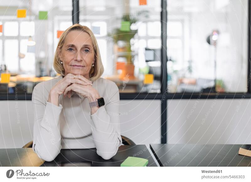 Porträt einer selbstbewussten, reifen Geschäftsfrau, die im Büro am Schreibtisch sitzt Job Berufe Berufstätigkeit Beschäftigung Jobs geschäftlich Geschäftsleben