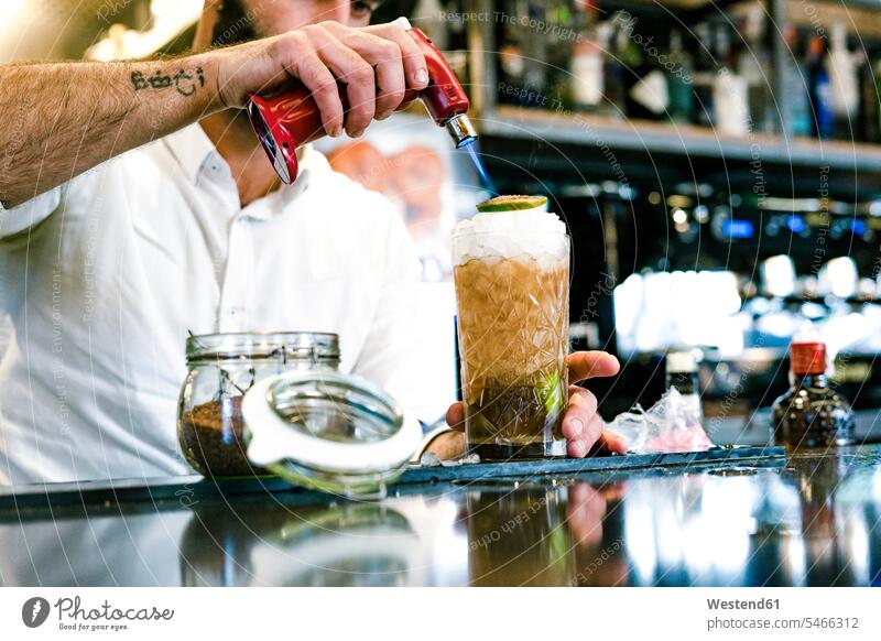 Nahaufnahme eines Barkeepers bei der Zubereitung eines Cocktails Barmann zubereiten Longdrink Longdrinks Gastronomie Alkohol Alkoholische Getraenke