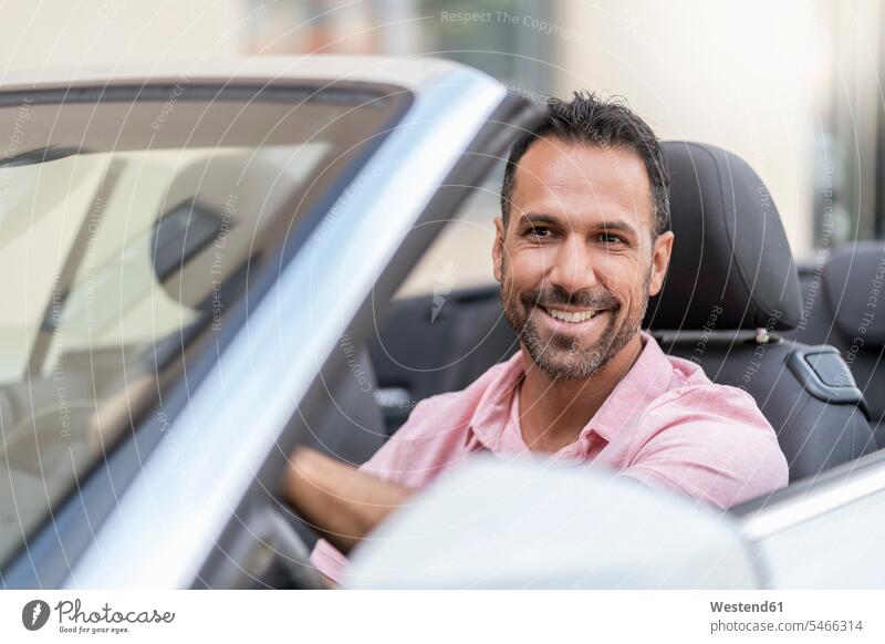 Porträt eines lächelnden Mannes, der Cabrio fährt Europäer Kaukasier Europäisch kaukasisch Wohlstand Vermögen Reichtum reich Auto Wagen PKWs Automobil Autos