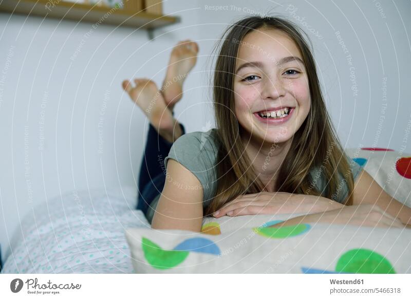 Porträt eines lachenden Mädchens auf dem Bett liegend liegt Betten Portrait Porträts Portraits weiblich Kind Kinder Kids Mensch Menschen Leute People Personen