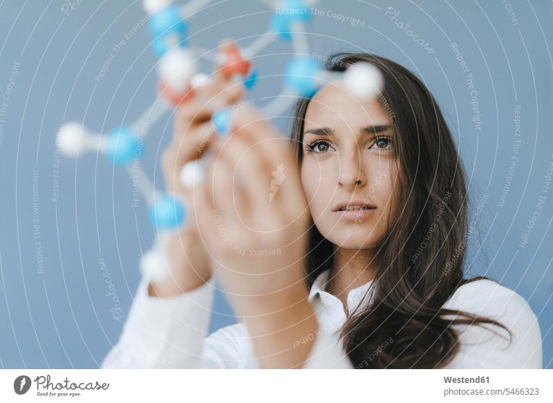 Weibliche Wissenschaftlerin mit Molekülmodell, die nach Lösungen sucht Frau weiblich Frauen Molekularmodell Wissenschaftlerinnen halten Erwachsener erwachsen