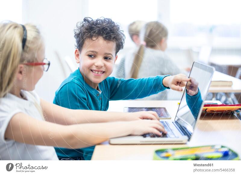 Schüler und Schülerin benutzen gemeinsam einen Laptop im Unterricht Schule Klassenzimmer Schulklasse Gemeinsam Schulkind Bildung Computer Unterrichtsstunde