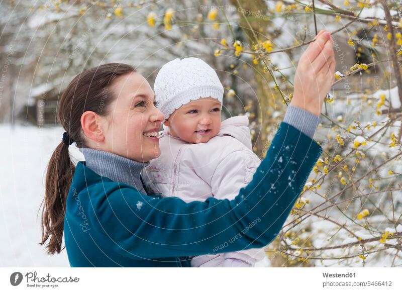 Porträt einer glücklichen Mutter mit Mädchen in schneebedeckter Landschaft verschneit Baby Babies Babys Säuglinge Kind Kinder Landschaften Portrait Porträts