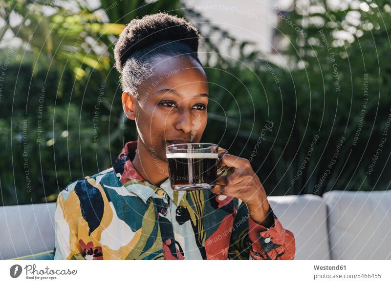 Porträt einer jungen Frau, die im Garten schwarzen Kaffee trinkt Gläser Trinkglas Trinkgläser Kleider Couch Couches Liege Sofas entspannen relaxen Jahreszeiten