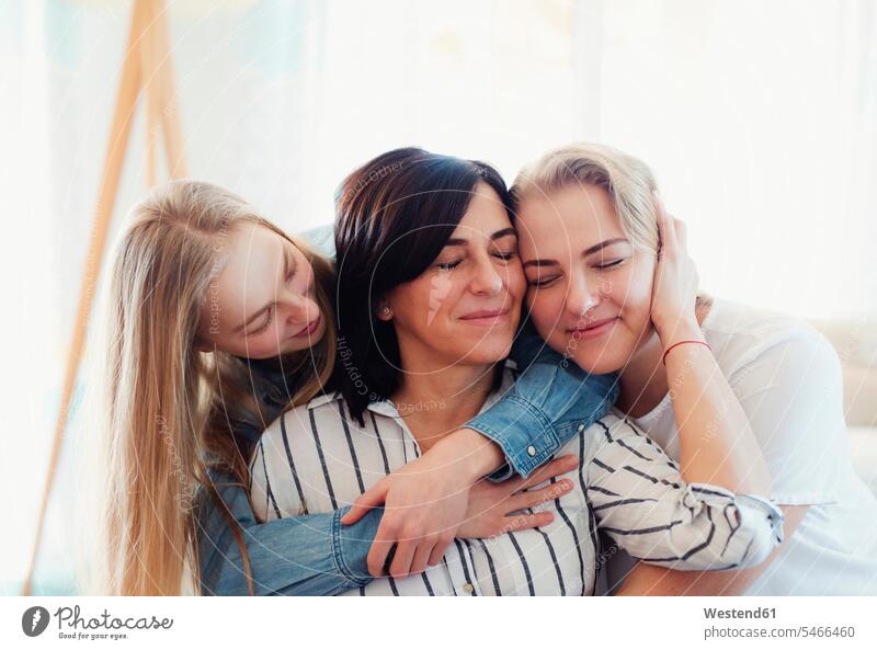 Töchter zu Besuch, die ihre Mutter umarmen Leute Menschen People Person Personen Europäisch Kaukasier kaukasisch erwachsen Erwachsene Frauen weiblich jung