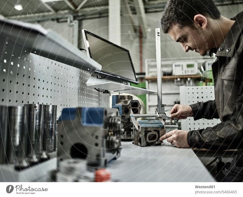 Arbeiter in einer metallverarbeitenden Fabrik - Messzylinderkopf mit Messschieber messen abmessen Werkstatt Werkstätte Werkstaette Werkstaetten Werkstätten