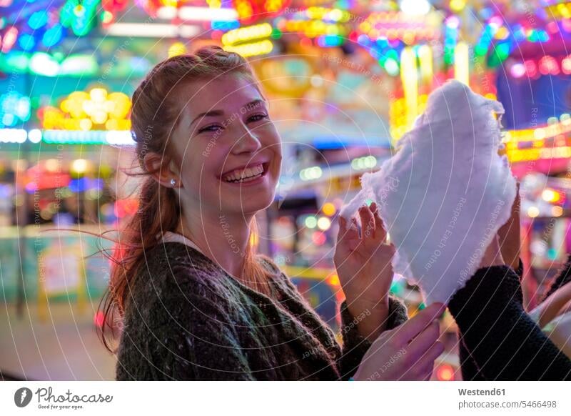 Porträt eines glücklichen rothaarigen Teenagers mit Zuckerwatte auf dem Oktoberfest abends entspannen relaxen entspanntheit relaxt freuen Frohsinn Fröhlichkeit
