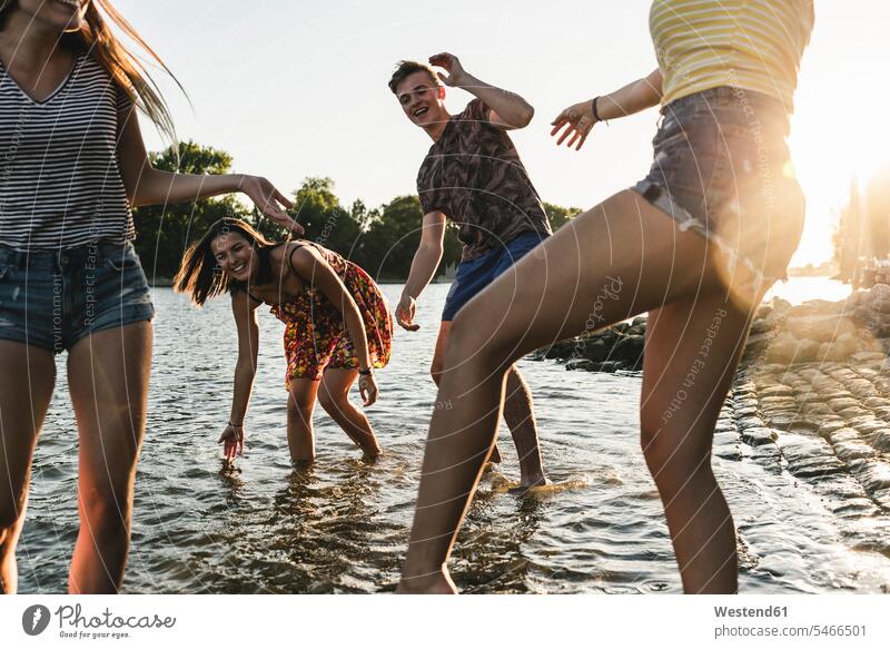 Gruppe glücklicher Freunde amüsiert sich bei Sonnenuntergang in einem Fluss Fluesse Fluß Flüsse Sonnenuntergänge Glück glücklich sein glücklichsein Spaß Spass