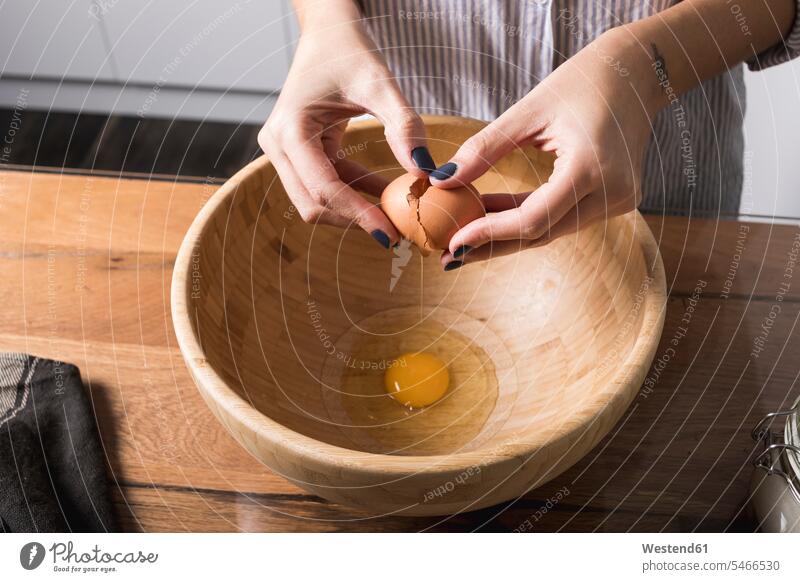 Frau bricht Ei, Holzschüssel Rührschüssel Hand Hände backen Eierschale Eierschalen zerbrechen auseinanderbrechen Zubereitung zubereiten Eigelb Dotter Eidotter