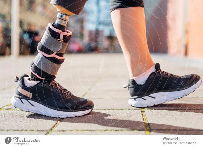 Nahaufnahme der Beine einer sportlichen Frau mit Beinprothese in der Stadt gehend geht fit gesund Gesundheit Muße Lifestyles außen draußen im Freien staedtisch