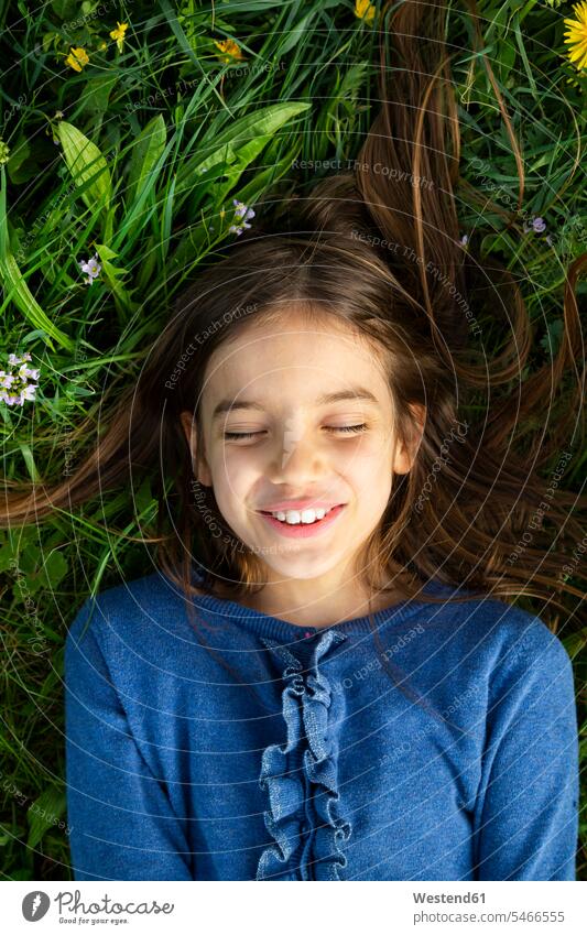 Porträt eines Mädchens mit geschlossenen Augen, das sich im Frühling auf einer Wiese entspannt Jahreszeiten Frühjahr Lenz entspannen relaxen entspanntheit