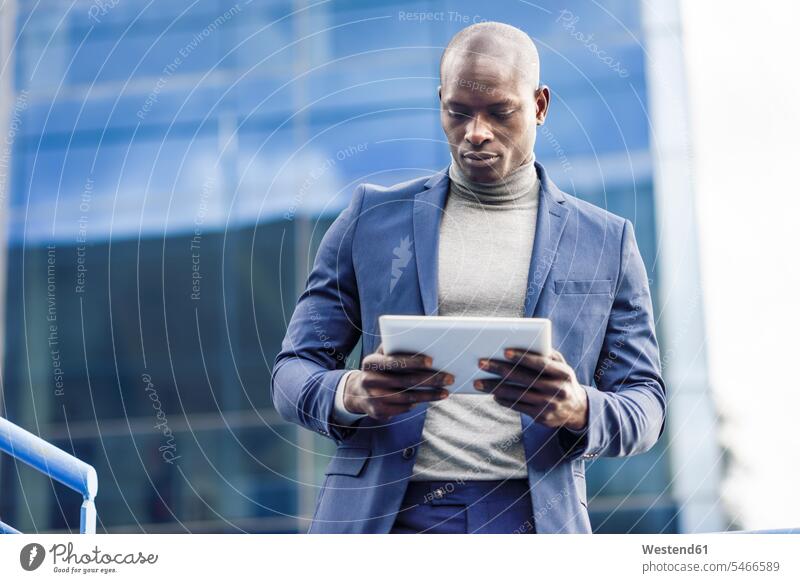 Porträt eines smarten Geschäftsmannes, der ein digitales Tablet im Freien benutzt Businessmann Businessmänner Geschäftsmänner benutzen Portrait Porträts