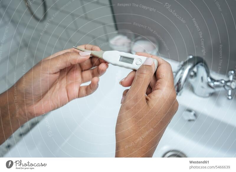 Nahaufnahme einer Frau, die ein Thermometer im Badezimmer hält daheim zu Hause Gesundheit Gesundheitswesen medizinisch Erkrankung Erkrankungen Krankheiten