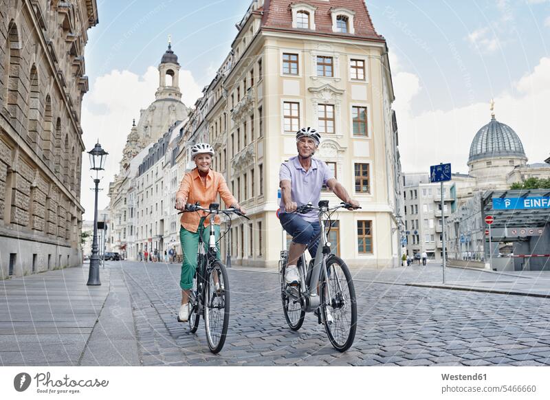 Ältere Touristen fahren mit dem Elektrofahrrad gegen die Frauenkirche in Dresden, Deutschland Farbaufnahme Farbe Farbfoto Farbphoto Außenaufnahme außen draußen