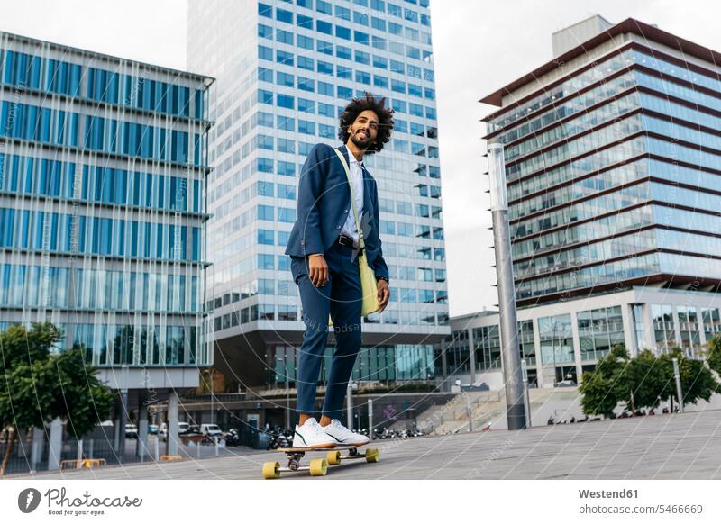 Spanien, Barcelona, junger Geschäftsmann fährt Skateboard in der Stadt fahren Rollbretter Skateboards Mann Männer männlich staedtisch städtisch Businessmann