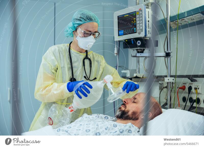 Arzt mit Beutelventilmaske bei der Versorgung von Patienten auf der Notfallstation eines Krankenhauses Leute Menschen People Person Personen Europäisch