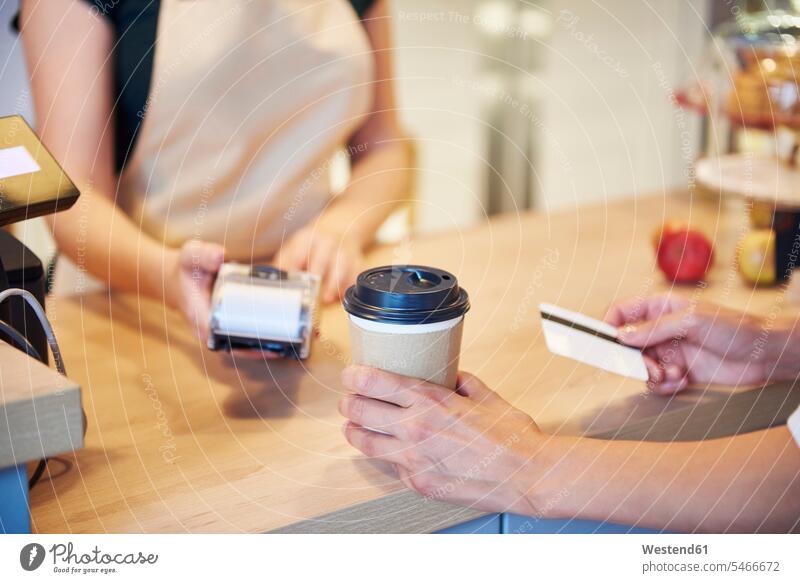 Nahaufnahme eines Kunden, der in einem Cafe mit Kreditkarte bezahlt Kundschaft EC-Karte Kreditkarten bezahlen Kaffeehaus Bistro Cafes Café Cafés Kaffeehäuser
