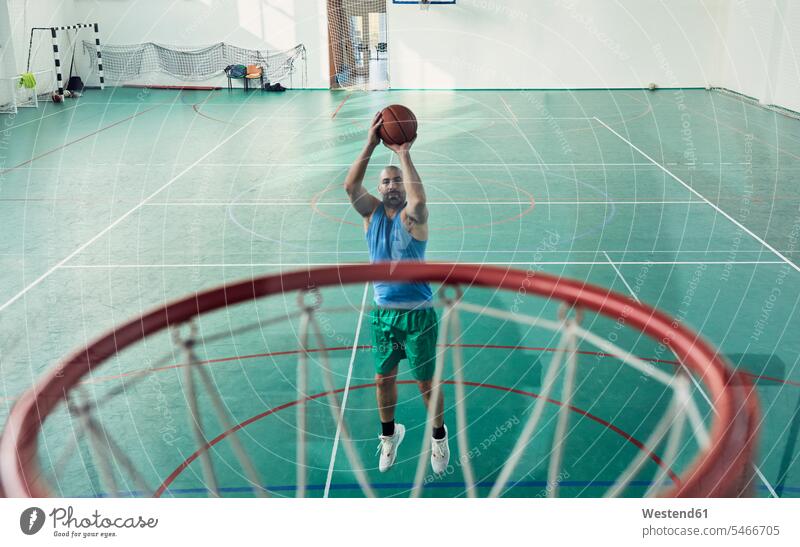 Mann spielt Basketball, Basketballkorb, Halle springen hüpfen werfen Wurf Sprung Spruenge Sprünge Freizeitsport Basketballspieler Basketballer Sport