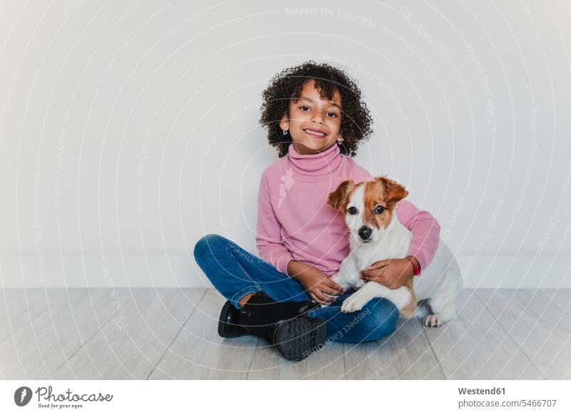 Porträt eines lächelnden kleinen Mädchens, das mit seinem Hund auf dem Boden sitzt Leute Menschen People Person Personen 1 Ein ein Mensch nur eine Person single