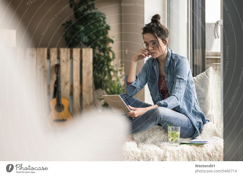 Frau sitzt am Fenster zu Hause mit Laptop Zuhause daheim weiblich Frauen Notebook Laptops Notebooks sitzen sitzend Erwachsener erwachsen Mensch Menschen Leute