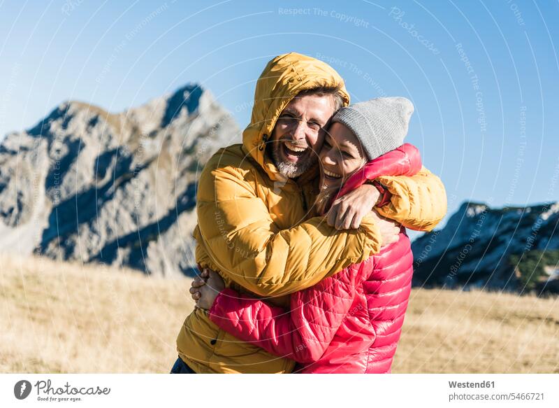 Österreich, Tirol, glückliches Paar umarmt auf einer Wanderung in den Bergen Glück glücklich sein glücklichsein Wandertour Gebirge Berglandschaft