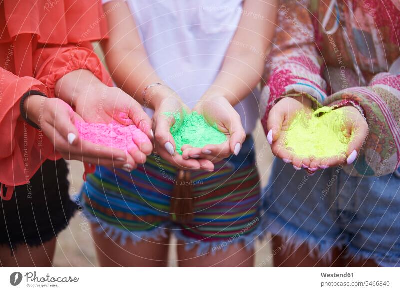 Holi-Farben in den Händen von Frauen Freundinnen Pulver Hand Musikfestival Musiktage Musikfestspiele Farbpuder Puderfarbe halten Farbpulver Pulverfarbe Freunde