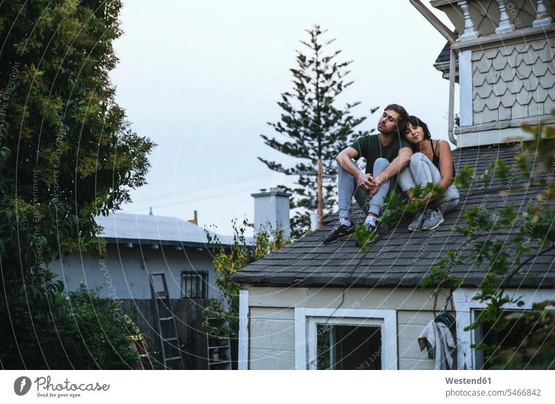 Entspanntes Paar sitzt auf dem Dach entspannt entspanntheit relaxt sitzen sitzend Pärchen Paare Partnerschaft Entspannung relaxen entspannen Mensch Menschen