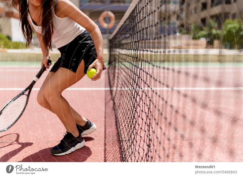 Tennisspielerin hält Schläger und Ball in der Hand, während sie auf dem Platz am Netz steht Farbaufnahme Farbe Farbfoto Farbphoto Spanien Außenaufnahme außen