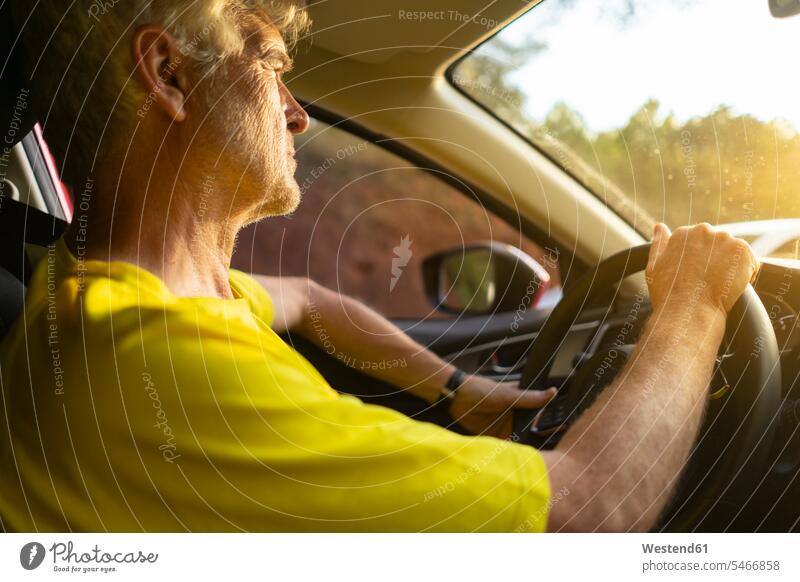 Älterer Mann fährt ein Auto bei Sonnenuntergang Männer männlich Senior ältere Männer älterer Mann Senioren Sonnenuntergänge fahren fahrend fahrender fahrendes