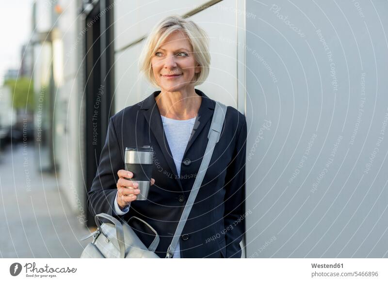Lächelnde ältere Geschäftsfrau mit Kaffee zum Mitnehmen im Freien Geschäftsfrauen Businesswomen Businessfrauen Businesswoman Zuversicht Zuversichtlich