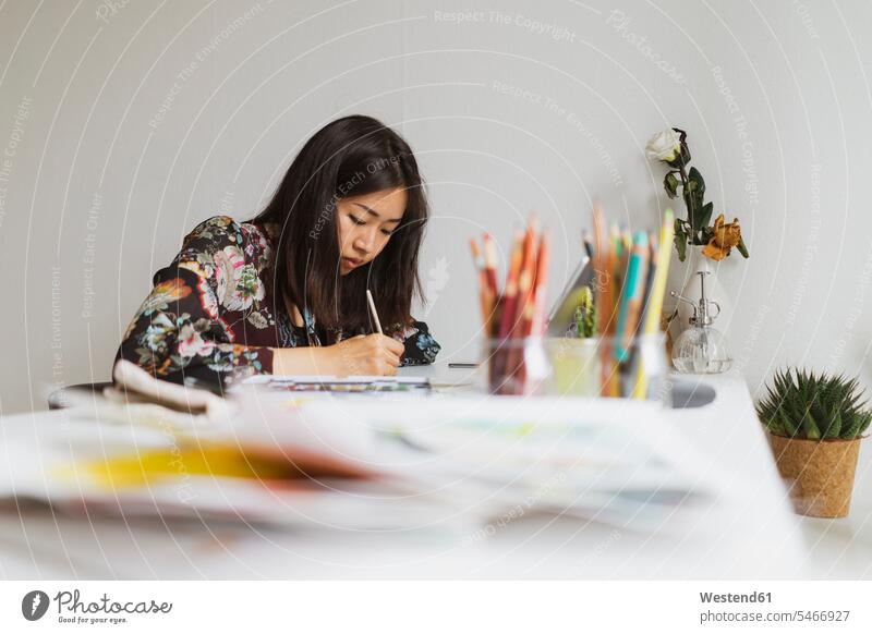 Illustratorin malt am Arbeitstisch in einem Atelier malen Arbeitstische Beruf Berufstätigkeit Berufe Beschäftigung Jobs differenzierter Fokus Aufmerksamkeit