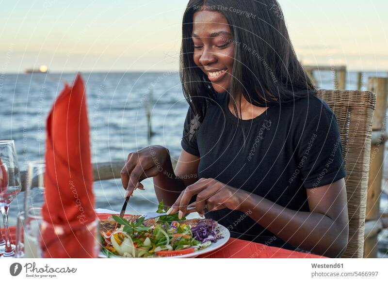 Junge Frau genießt ein Abendessen an der Waterfront, Maputo, Mosambik Leute Menschen People Person Personen Afrikanisch Afrikanische Abstammung dunkelhäutig