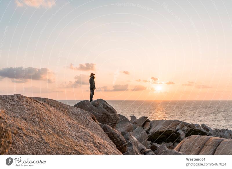 Italien, Sardinien, Mann steht bei Sonnenuntergang auf einem Felsen und schaut zu Aussicht Ausblick Ansicht Überblick Männer männlich stehen stehend schauen