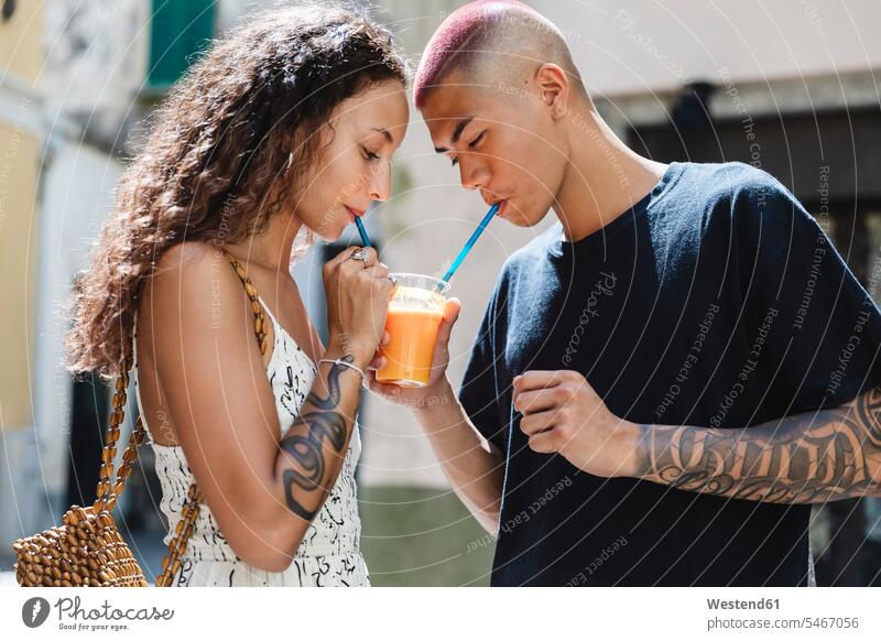Junges Paar trinkt gemeinsam Fruchtsaft Touristen Rucksäcke Strohhalme Trinkhalm Trinkhalme gefühlvoll Emotionen Empfindung Empfindungen fühlen Gefühl Gefühle