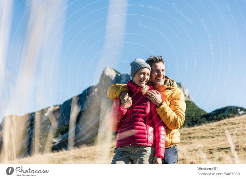 Österreich, Tirol, glückliches Paar, das sich auf einer Wanderung in den Bergen umarmt Gebirge Berglandschaft Gebirgslandschaft Gebirgskette Gebirgszug Pärchen