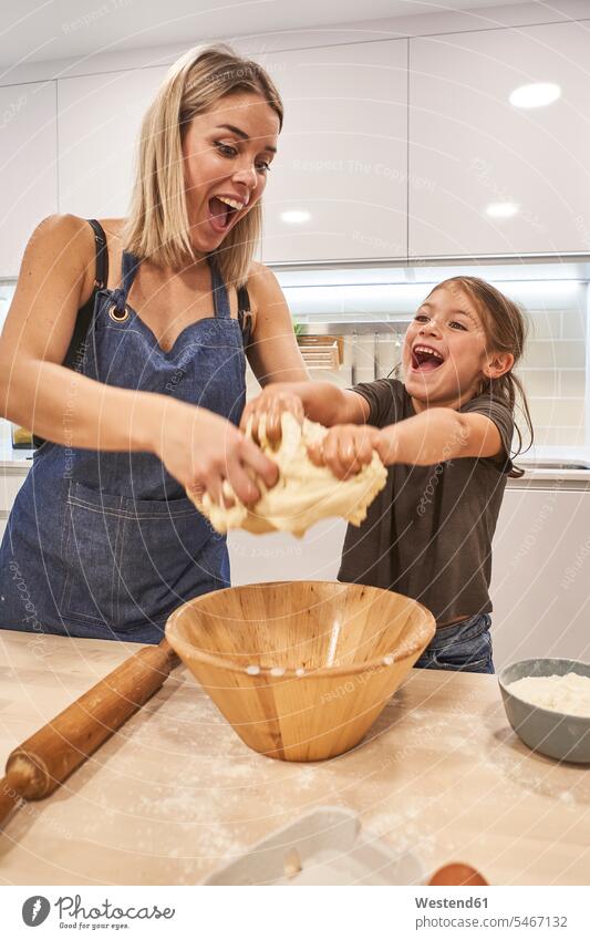 Verspielte Mutter und Tochter schreien beim Kneten von Pizzateig in der heimischen Küche Farbaufnahme Farbe Farbfoto Farbphoto Spanien Freizeitbeschäftigung