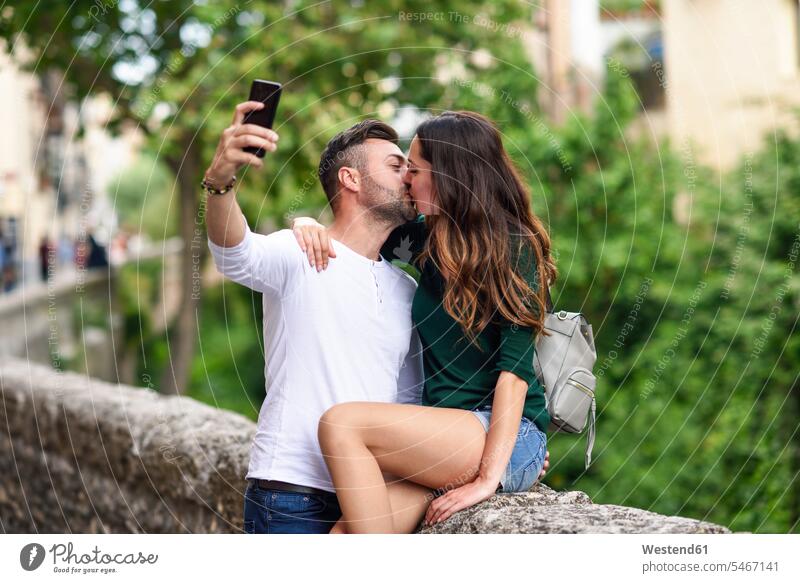 Verliebtes Paar in der Stadt, das sich küsst und ein Selfie macht Zuneigung Gasse Gassen Selfies verliebt küssen Küsse Kuss Liebe lieben Pärchen Paare