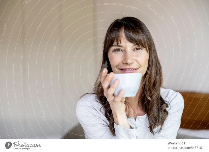 Porträt einer entspannten Frau, die eine Tasse Kaffee zu Hause hält Leute Menschen People Person Personen Europäisch Kaukasier kaukasisch 1 Ein ein Mensch