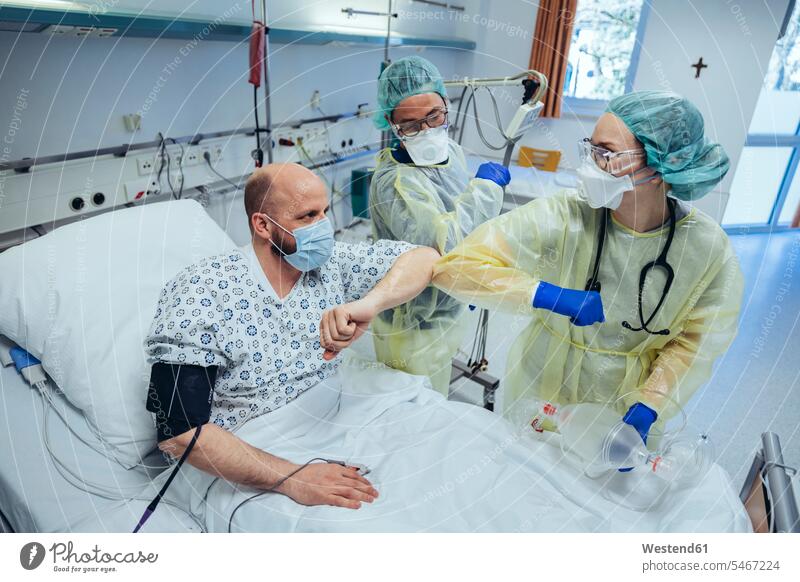 Ärzte machen Ellbogenstoß mit geheiltem Patienten auf der Notfallstation eines Krankenhauses Arbeitskollege Arbeitskollegen Kollege Gesundheit Gesundheitswesen