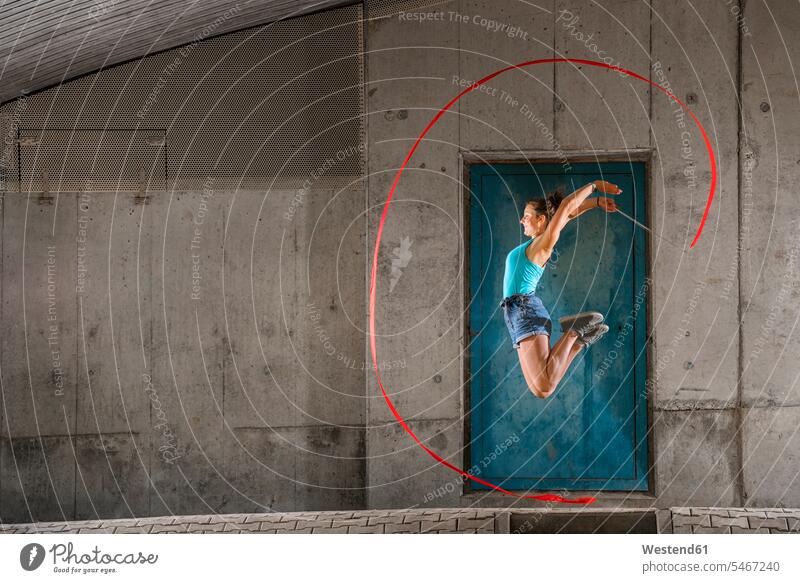 Junge Frau, die beim Aerobic gegen eine Betonwand springt Farbaufnahme Farbe Farbfoto Farbphoto Deutschland Außenaufnahme außen draußen im Freien Tag