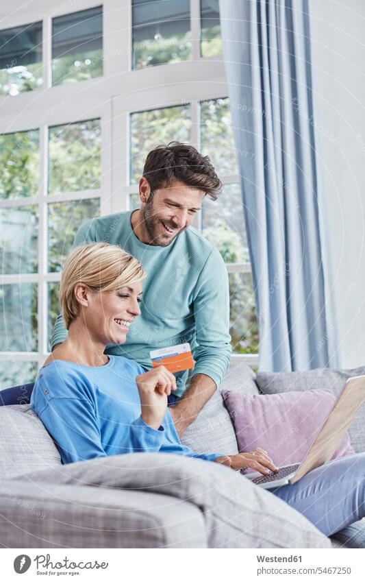 Glückliches Paar beim Online-Shopping zu Hause einkaufen shoppen Einkauf Zuhause daheim Online Shopping Internet-Shopping Onlineshopping glücklich