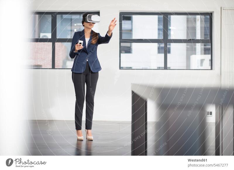 Geschäftsfrau mit VR-Brille im Büro Brillen Geschäftsfrauen Businesswomen Businessfrauen Businesswoman Frau weiblich Frauen Virtuelle Realität